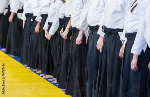 People in kimono and hakama standing in a long line on martial arts training seminar. Selective focus