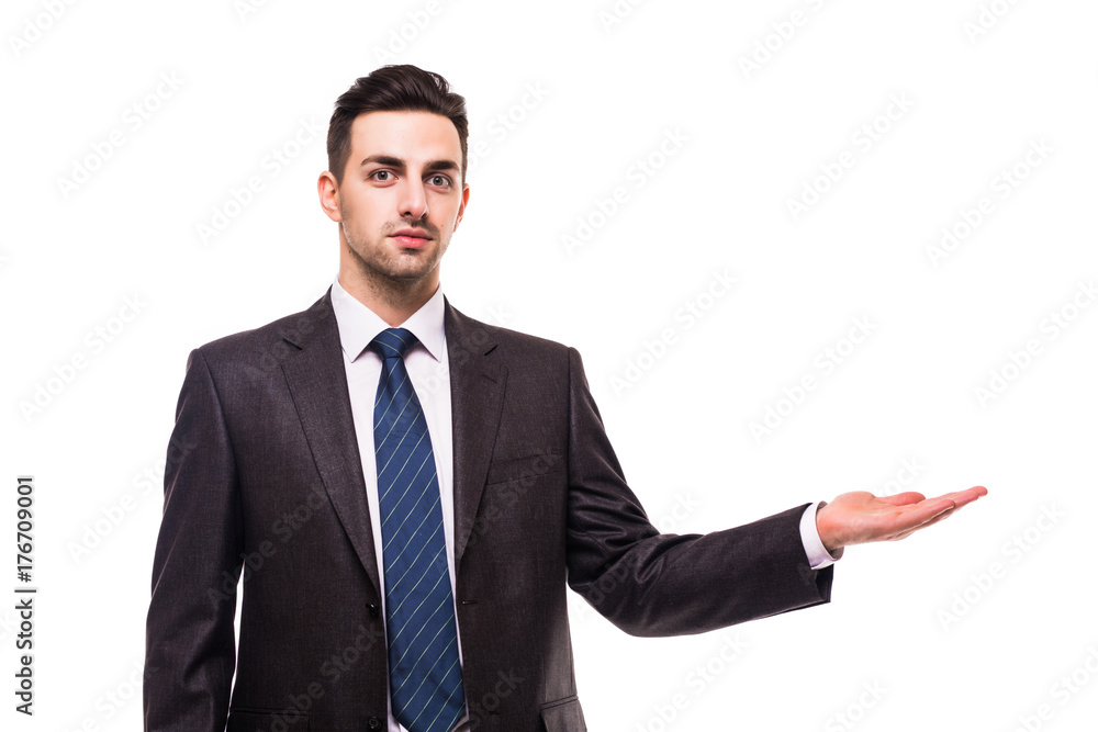 full length picture of a young business man presenting something in the back with one hand in his pocket while looking at the camera with a smile on his face, on white background full length picture of a young business man presenting something in the back with one hand in his pocket while looking at the camera with a smile on his face, on white background