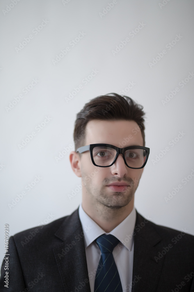 Portrait of a young and fashion businessman with nerd glasses on gray Portrait of a young and fashion businessman with nerd glasses on gray