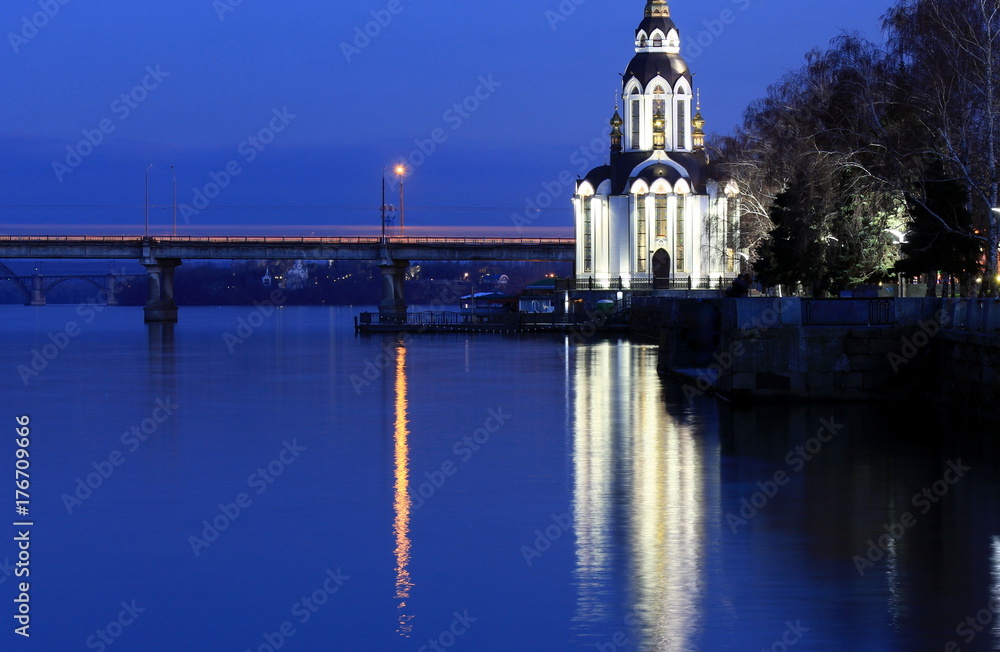 Beautiful church  with illuminating  at autumn night, lights reflected in the river Dnieper. View of the city Dnipro city (Dnepr, Dnepropetrovsk,  Dnipropetrovsk)  Ukraine.
