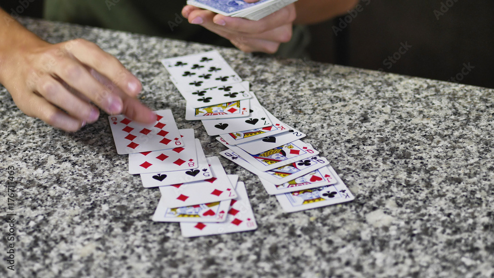 Obraz premium Two young men relaxing together and playing cards spending time at home.