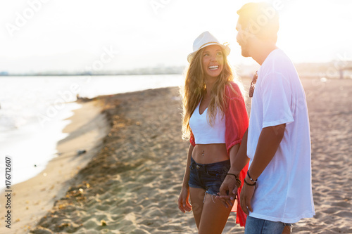 Beautiful young couple in love walking on the beach.