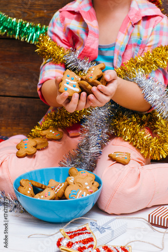 Sweet Christmas. Child dream life. Unrecognizable girl with many gingerbread. Festive mood on New Year, food concept