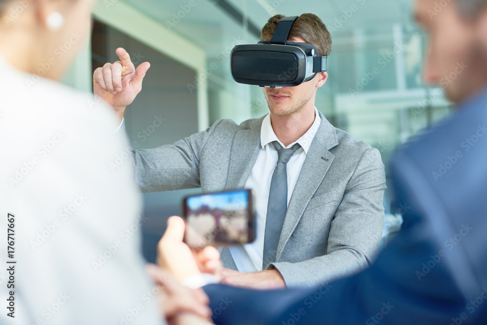 Fotografie Young beaded entrepreneur using VR headset while having start-up project discuss