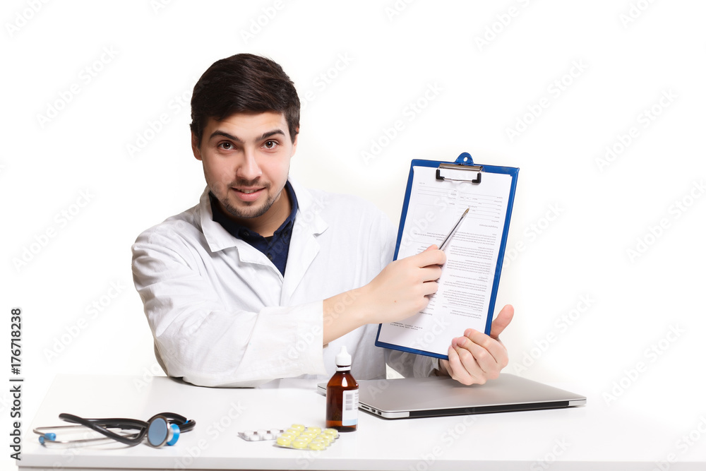 handsome doctor man in his office at the desk, looking at the lens handsome doctor man in his office at the desk, looking at the lens