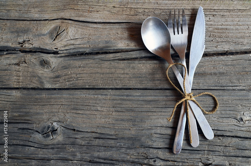 Cutlery set:fork,spoon and knife on rustic wooden table.Cutlery on old wooden background.Can be used as background menu for restaurant.Top view.Copy space.Selective focus.