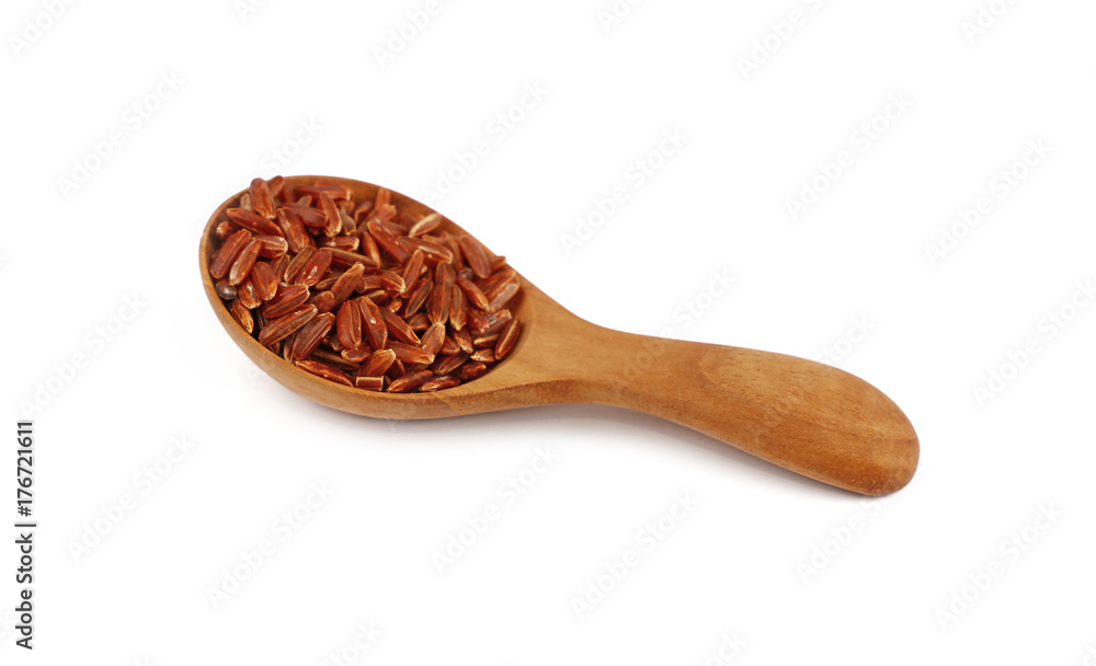 Red brown raw rice in wooden scoop on white Red brown raw rice in wooden scoop on white