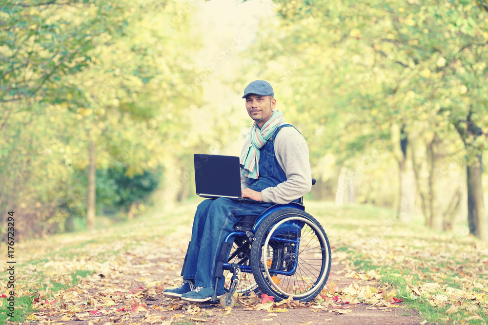 erfolgreicher Rollstuhlfahrer mit Laptop im Park erfolgreicher Rollstuhlfahrer mit Laptop im Park