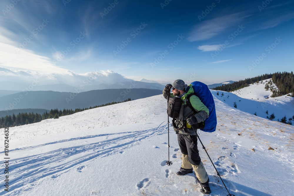 Hiker is posing to the camera in winter mountains Hiker is posing to the camera in winter mountains