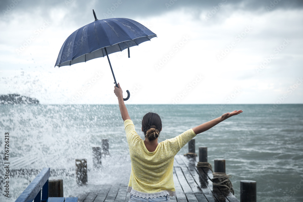 a young girl on a pier with an umbrella