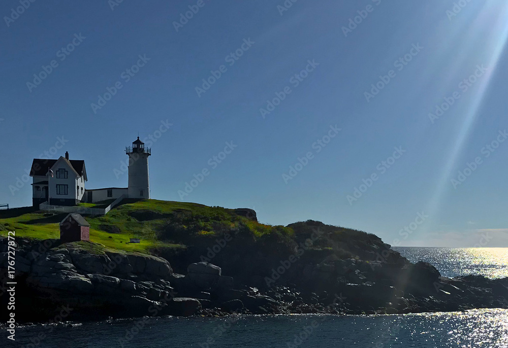 Lens flare and silhouette of lighthouse in the morning