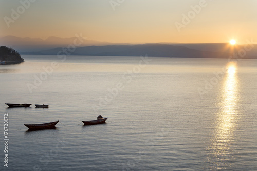 Wooden boat on the calm surface of the lake. Chivyrkuisky Bay. The Lake Baikal. Buryatia. Russia.