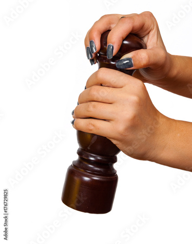 Pepper mill on female hands isolated on white background