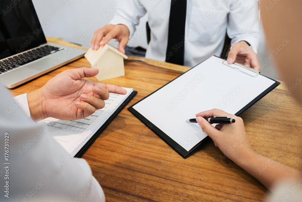 Real Estate agent with customer making contract signature and analyzing valuation Real Estate agent with customer making contract signature and analyzing valuation