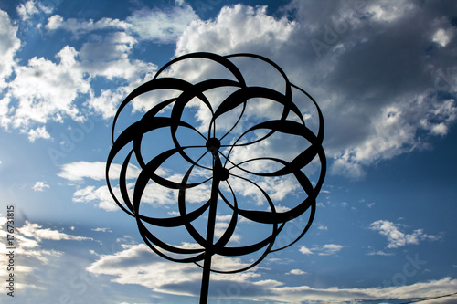 Garden Whirligig Silhouetted Against a Blue Cloudy Sky