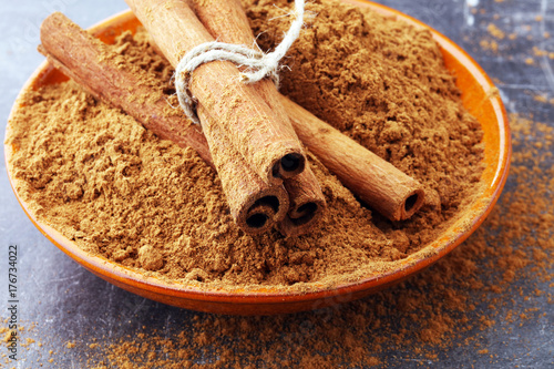 Ground cinnamon, cinnamon sticks, tied with jute rope and cinnamon powder in rustic style.