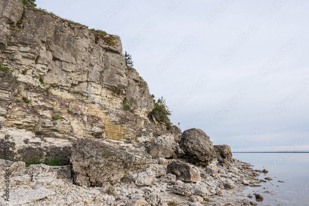 Sunset on the beach. Limestone cliff in the sea under blue sky and white clouds. Kesselaid, a small island in Estonia. Nordic countries, Europe