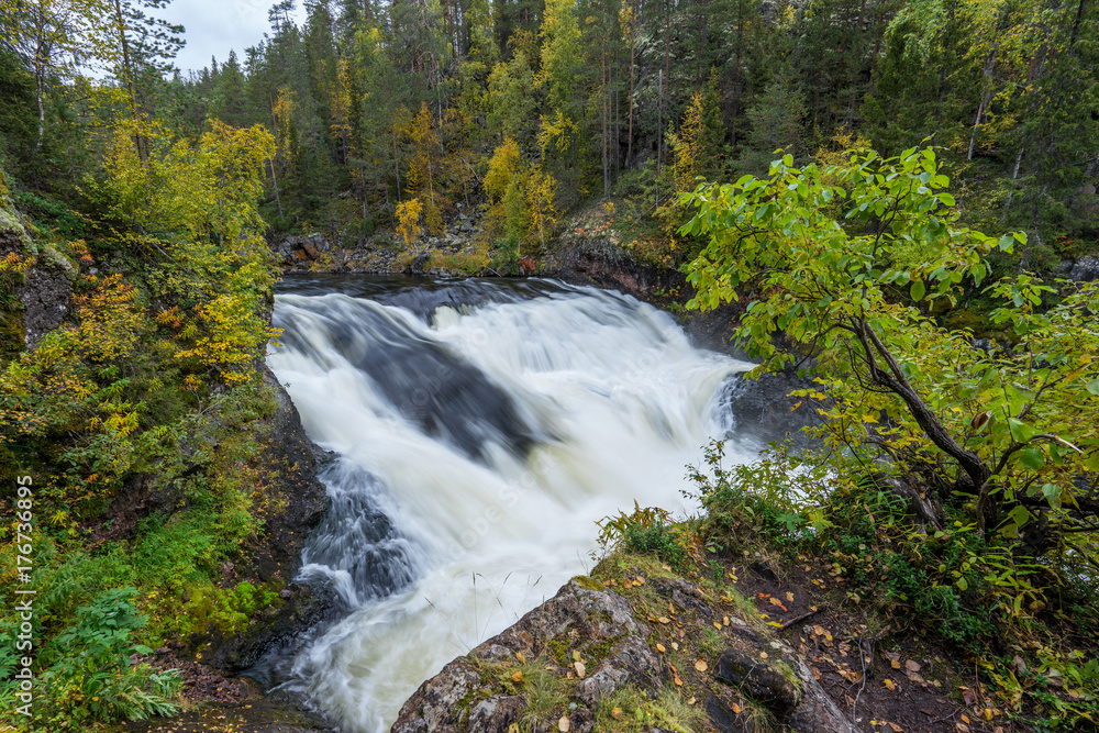 Cliff, stone wall, forest, waterfall and wild river view in autumn. Fall colors - ruska time in Myllykoski. One part of Karhunkierros Trail. Oulanka National Park in north Finland. Lapland, Europe Cliff, stone wall, forest, waterfall and wild river view in autumn. Fall colors - ruska time in Myllykoski. One part of Karhunkierros Trail. Oulanka National Park in north Finland. Lapland, Europe