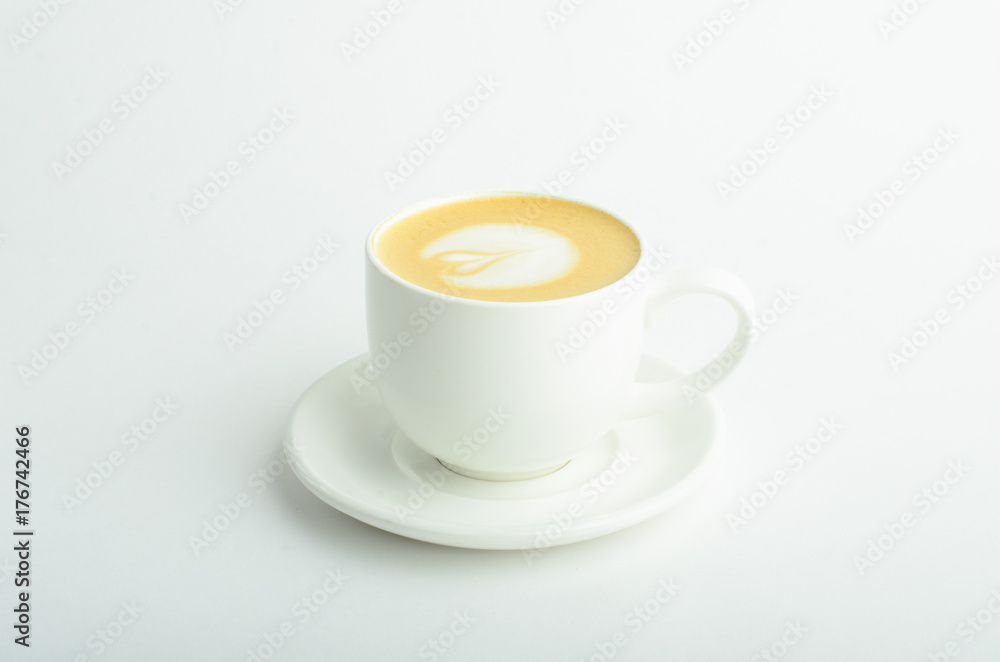 A cup of cappuccino coffee with heart shaped milk foam isolated on white background