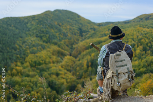 An old man in the outdoors in the mountains, place for writing text. Senior man on top of the mountain.