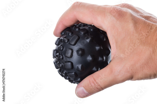 Hand holding a ball with spikes for myofascial massage. On white background. photo