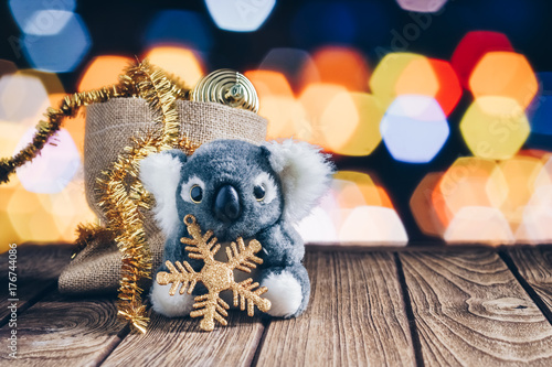 Photography Cute Koala decorated with Christmas decoration items on wood and bokeh backgroun