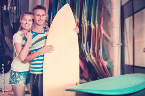 Couple is satisfied of colorful boards in store on the beach. © JackF