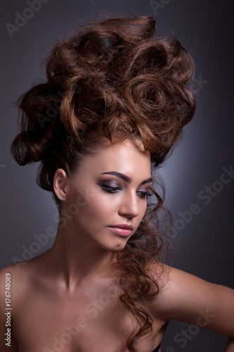 Portrait of a beautiful girl with a creative high hairstyle and makeup.