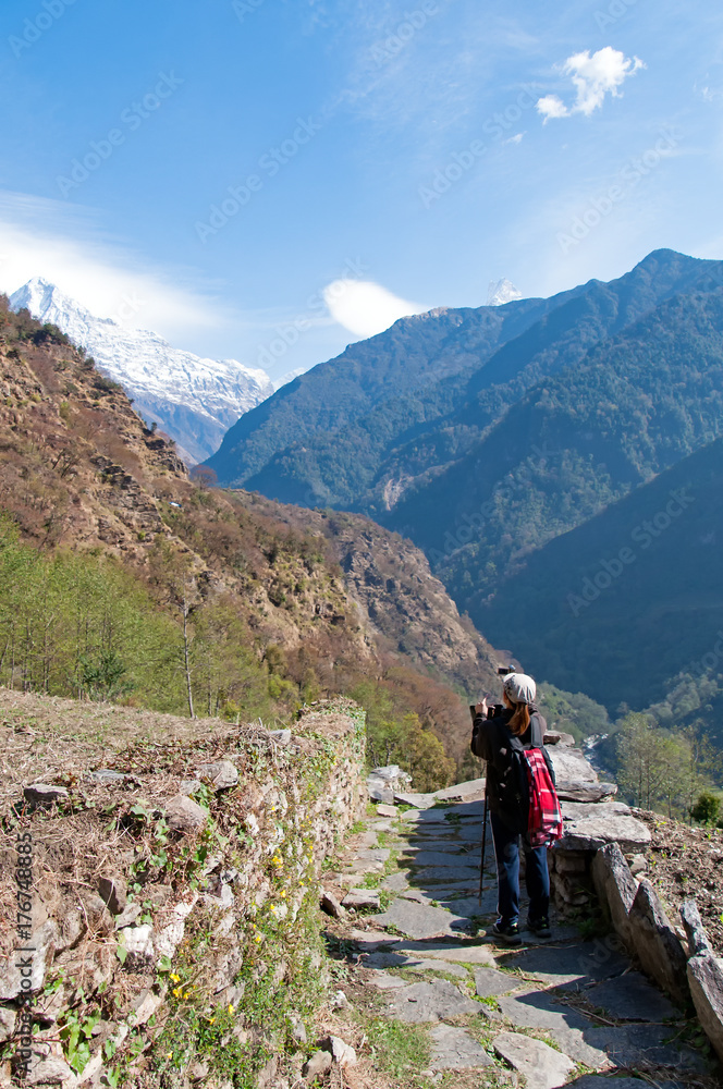 Unidentified person looking at the view of Annapurna Mountain Range at the trekking trails of Annapurna Himalayas Circuit in Ghandruk Village, Gandaki Region.