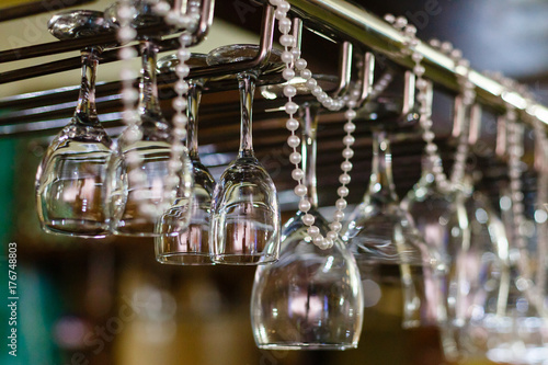 Empty glasses for wine above a bar rack