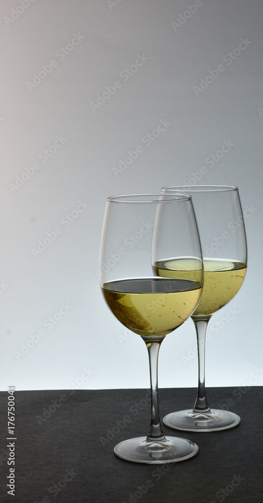 Two staggered glasses of white wine
