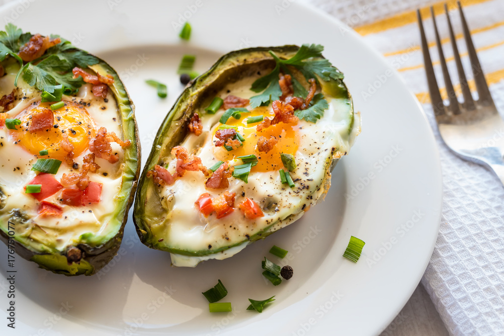 Eggs baked in avocado with bacon, red paprika and chive. Eggs baked in avocado with bacon, red paprika and chive.