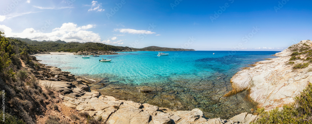 Boats in a small rocky cove with sandy beach in Corsica