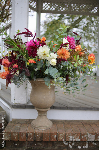White  Green  Magenta  and Orange Fall Wedding Floral Arrangement in a Stone Urn Outside