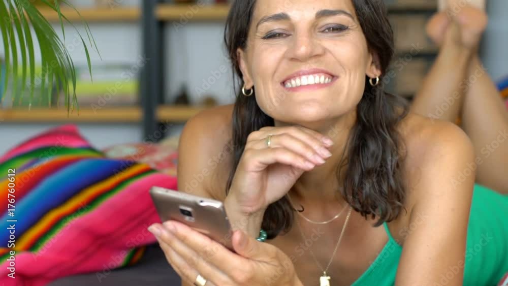 Beautiful woman in green dress browsing internet on smartphone and smiling to the camera
Beautiful woman in green dress browsing internet on smartphone and smiling to the camera