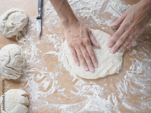 Female hands making dough for pizza 