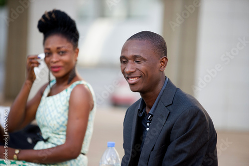 smiling young businessman sitting next to a young woman with a wallet in hand © vystekimages