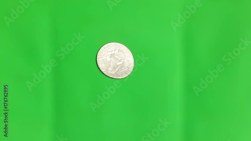 Flipping a coin in the air on green screen croma key. One dollar spinning slow motion tossing silver money making a choise old liberty