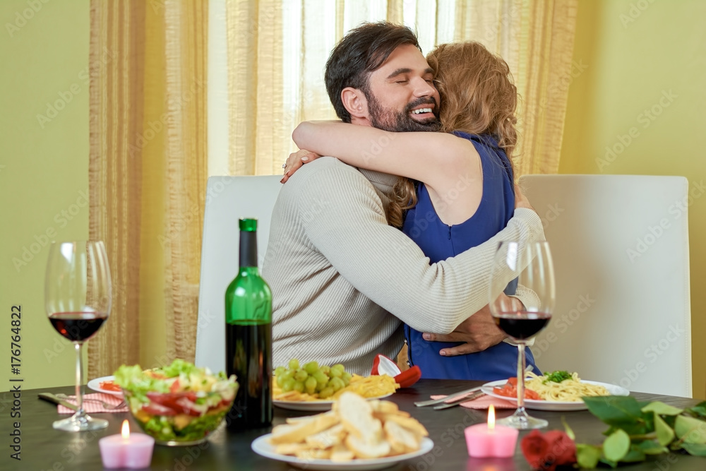 Couple at dinner table. Young man hugging woman. What is romance.