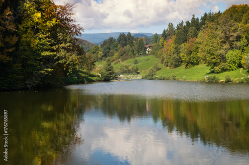 The bright autumn colors of the forest are reflected in the lake.