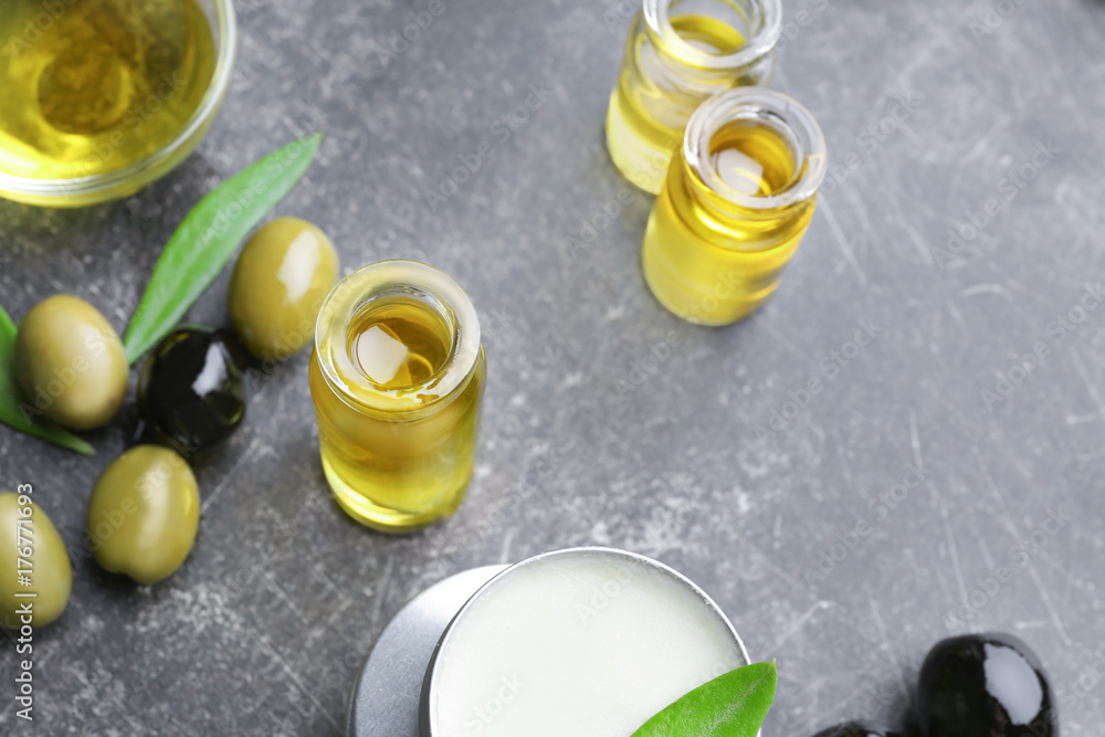Composition with olive oil and cosmetics on grey table Composition with olive oil and cosmetics on grey table