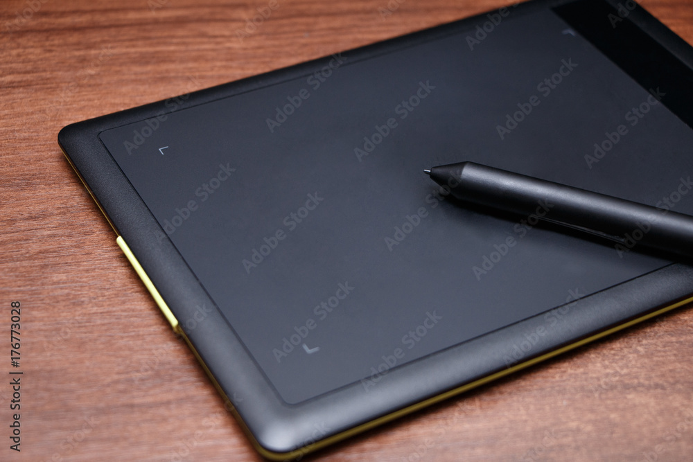 Black graphic tablet with a stylus closeup