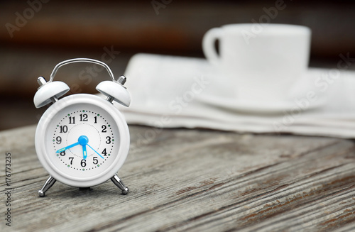 Alarm clock on wooden bench outdoors. Morning routine concept