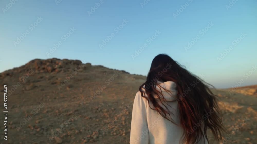 Young woman running and climbing a desert hill during sunset Young woman running and climbing a desert hill during sunset