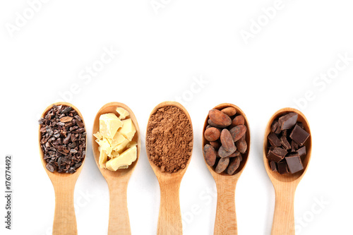 Spoons with different cocoa products on white background