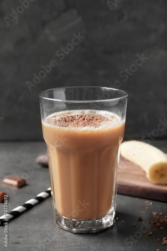 Glass with chocolate protein shake on table