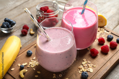 Glasses with berry protein shakes on table photo
