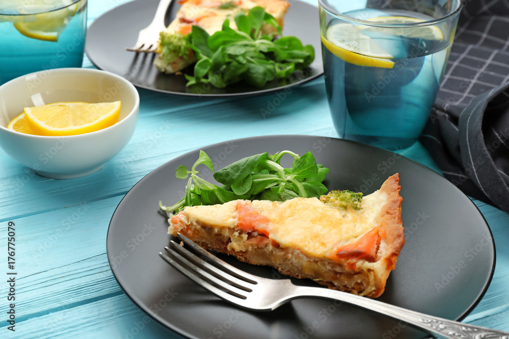Plate with piece of salmon quiche pie on table Plate with piece of salmon quiche pie on table