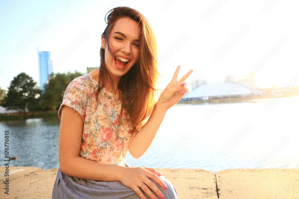 Woman with white teeth thinking and looking sideways in a park in summer