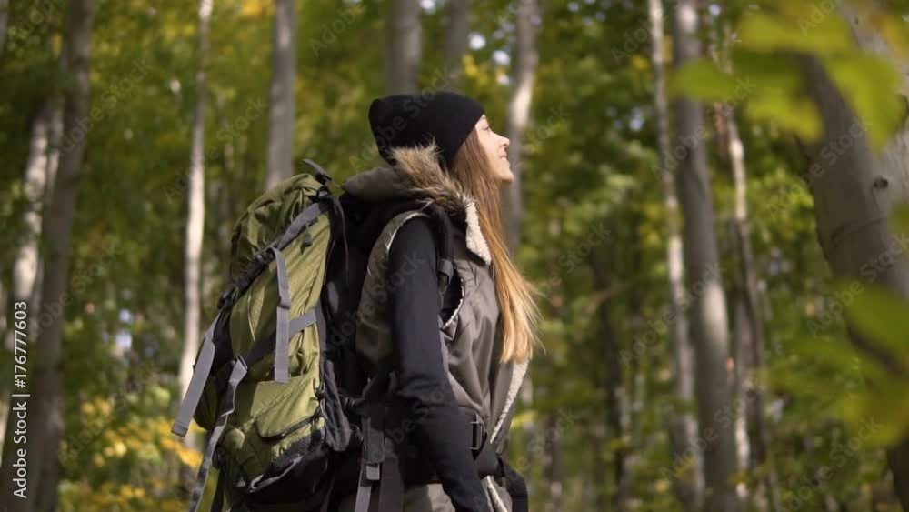 Smiling tourist, in black hat and warm waistcoat, turning around, slowmotion on sunny day in the fall forest Smiling tourist, in black hat and warm waistcoat, turning around, slowmotion on sunny day in the fall forest